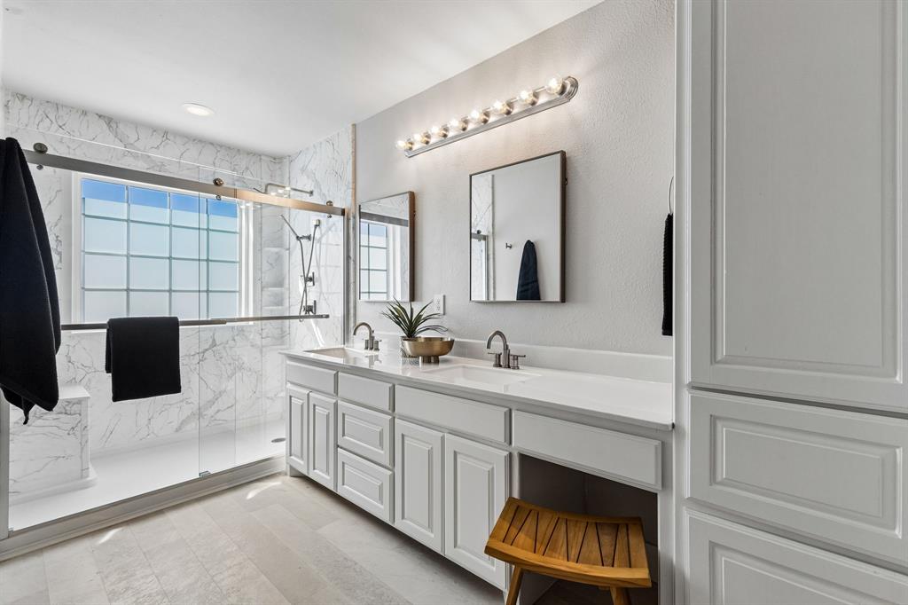 706 South Jupiter Road, Unit 307 Allen, TX 75002 - Photo 16 of 32 Large walk-in shower, dual vanity with integrated sinks and white countertops, complemented by white cabinetry and a built-in storage tower