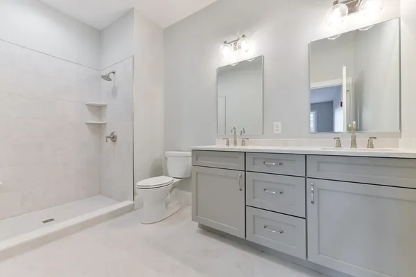 a bathroom with a double vanity sink toilet and shower