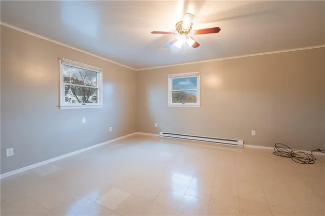 an empty room with chandelier fan and windows