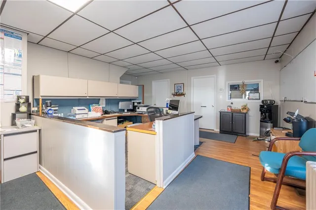 a kitchen with stainless steel appliances granite countertop a stove a refrigerator a sink a dining table and chairs with wooden floor