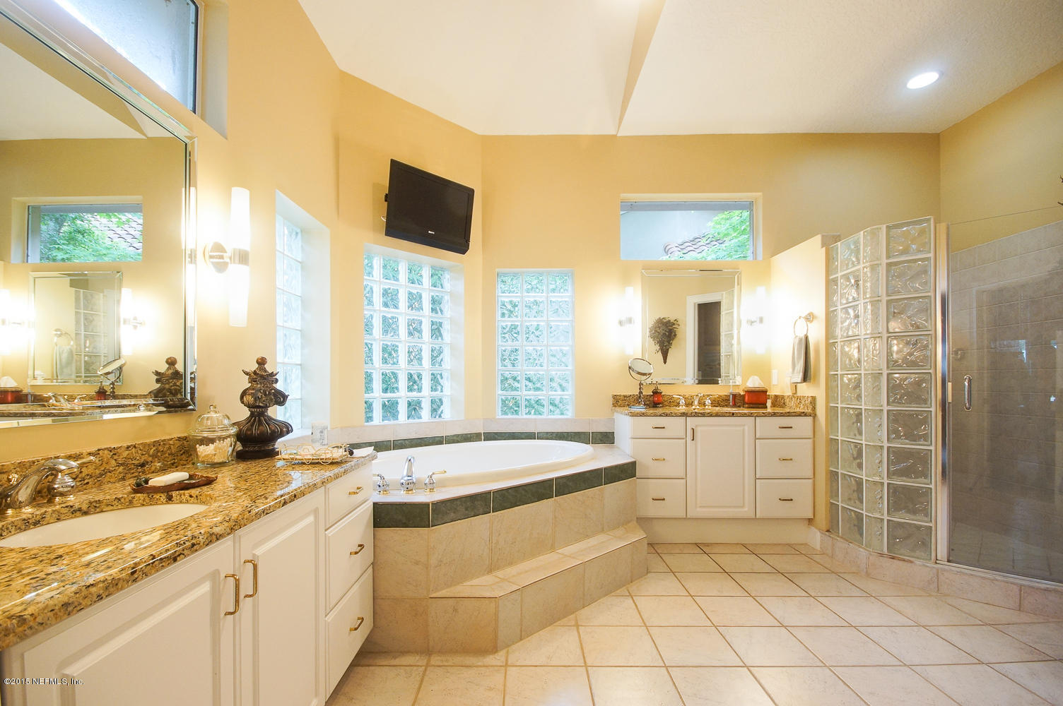 829 Queens Harbor Boulevard Jacksonville, FL 32225 - Photo 25 of 42 a large bathroom with a granite countertop sink a large mirror and a bathtub next to a window
