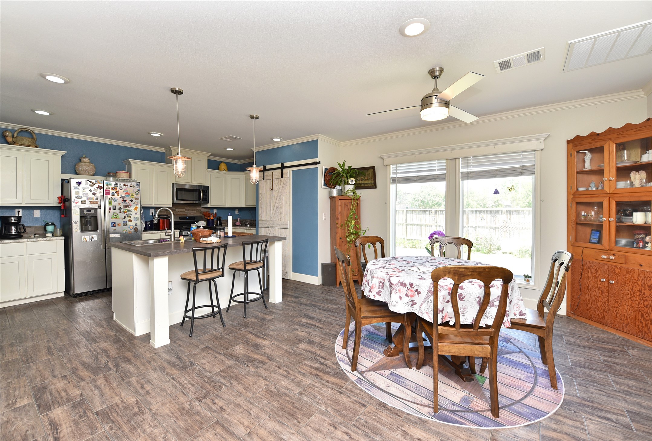 3221 Pecha Lane Rosenberg, TX 77471 - Photo 11 of 46 a dining room with kitchen island stainless steel appliances furniture a dining table and chairs