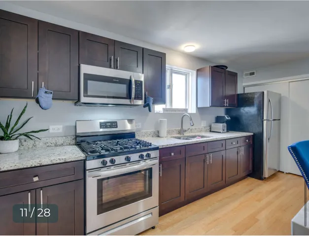a kitchen with granite countertop a sink and a stove top oven