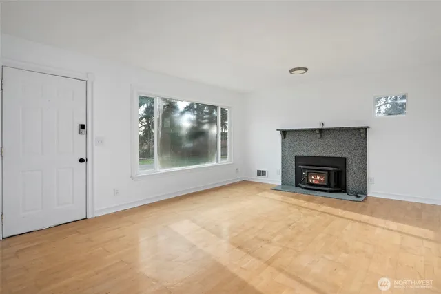 a view of an empty room with a fireplace and a fan
