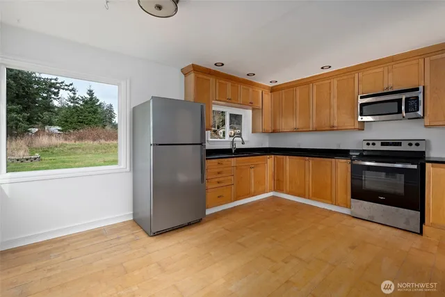 a kitchen with granite countertop a refrigerator and a stove top oven