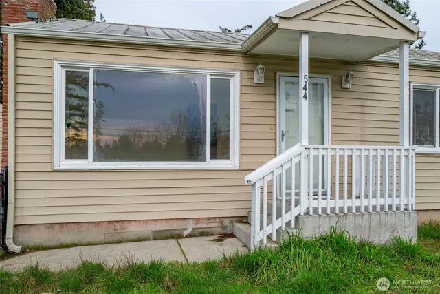 a view of a house with a small yard and wooden floor and fence