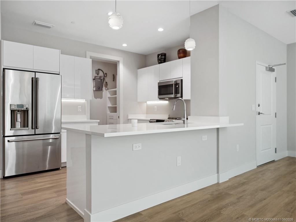 41 Southwest Seminole Street, Unit 208 Stuart, FL 34994 - Photo 8 of 46 a kitchen with kitchen island a sink stainless steel appliances and counter space