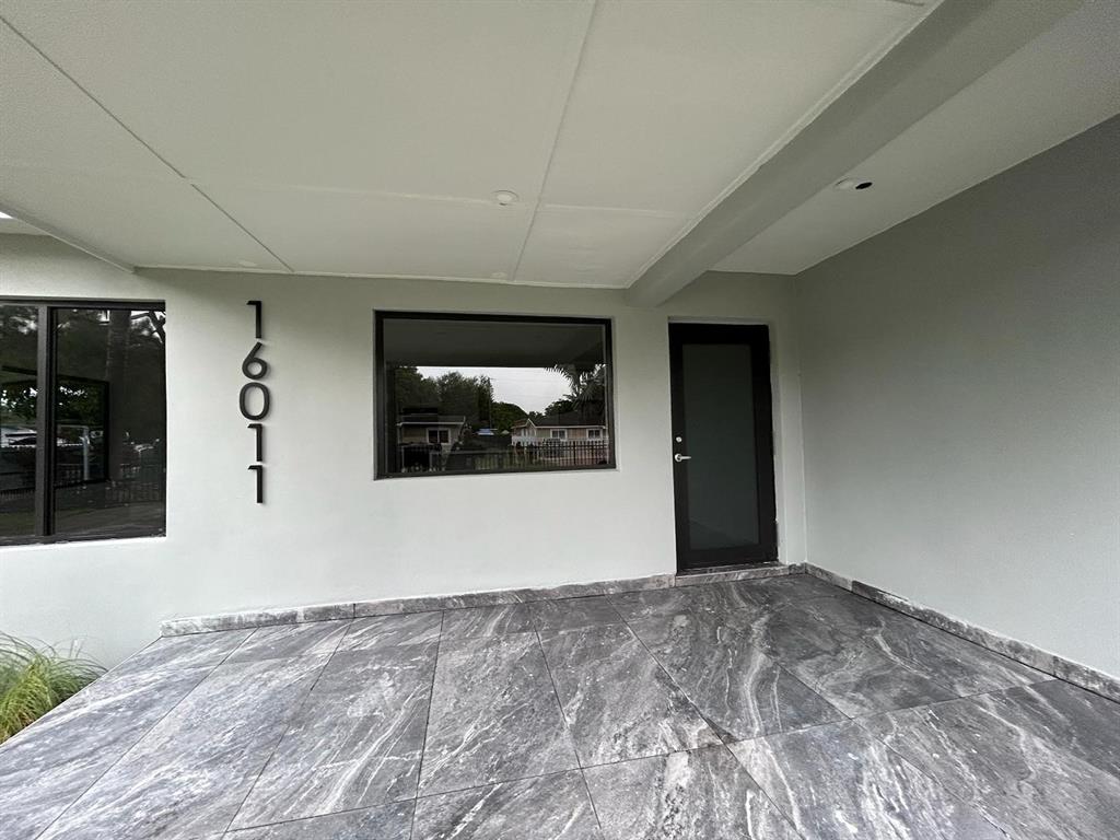 16011 Northwest 38th Court Opa-Locka, FL 33054 - Photo 11 of 38 a view of a hallway with wooden floor and front door