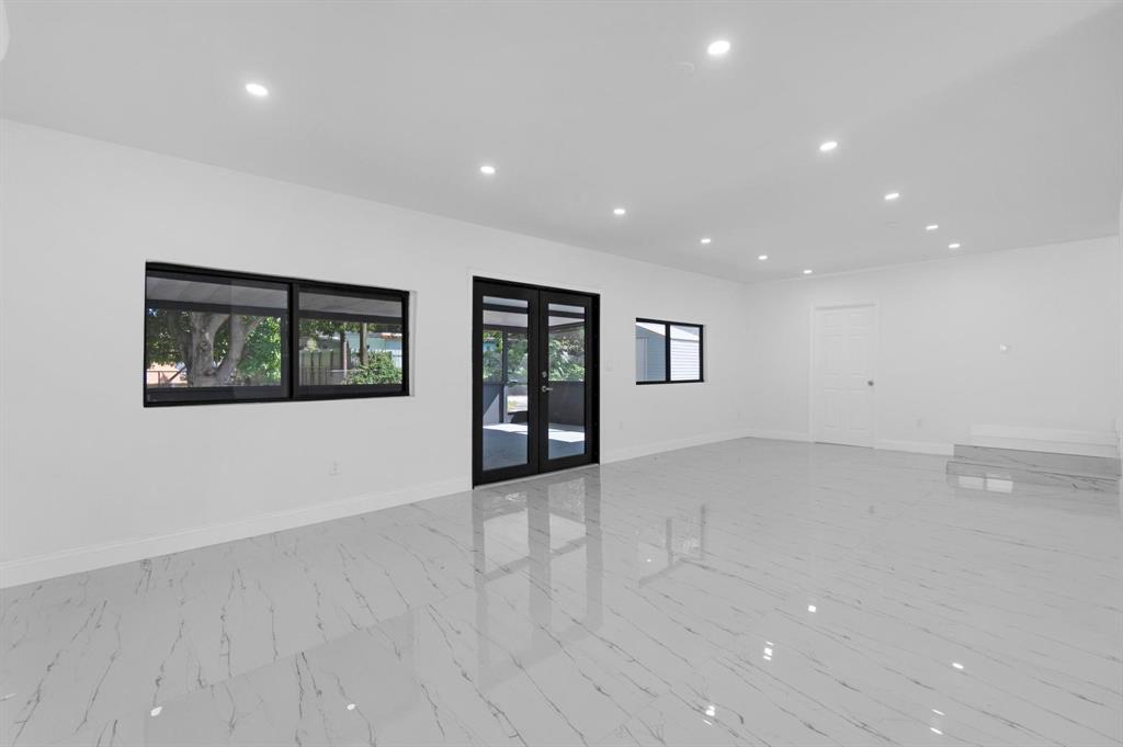 16011 Northwest 38th Court Opa-Locka, FL 33054 - Photo 19 of 38 an empty room with wooden floor and windows