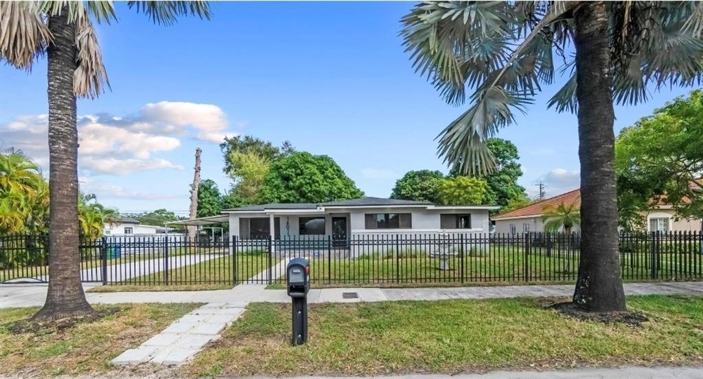 16011 Northwest 38th Court Opa-Locka, FL 33054 - Photo 33 of 38 a view of a house with a backyard and a tree