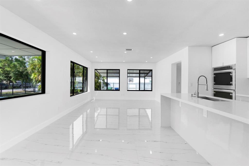 16011 Northwest 38th Court Opa-Locka, FL 33054 - Photo 6 of 38 a large white kitchen with sink and refrigerator