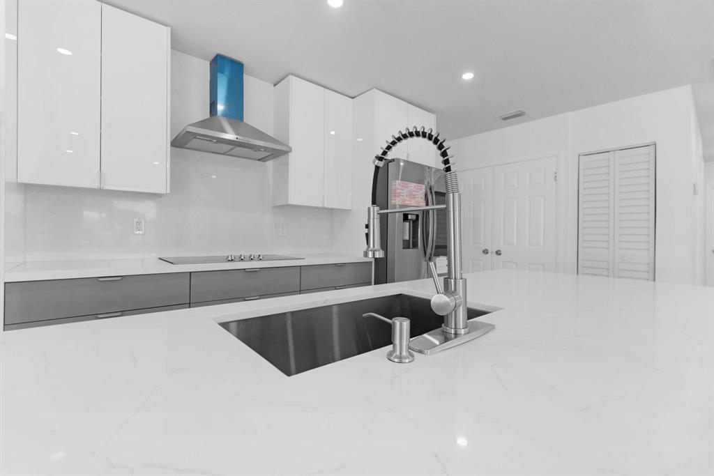 16011 Northwest 38th Court Opa-Locka, FL 33054 - Photo 8 of 38 a kitchen with granite countertop a sink and a stove top oven