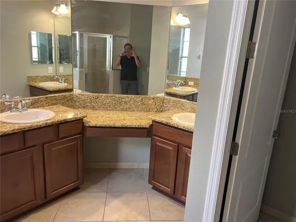 a bathroom with a granite countertop sink and a mirror
