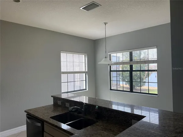 a kitchen with granite countertop a stove a sink and a window