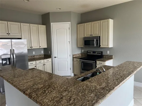a kitchen with granite countertop a refrigerator and a sink