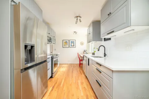 a kitchen with granite countertop a sink stove and refrigerator