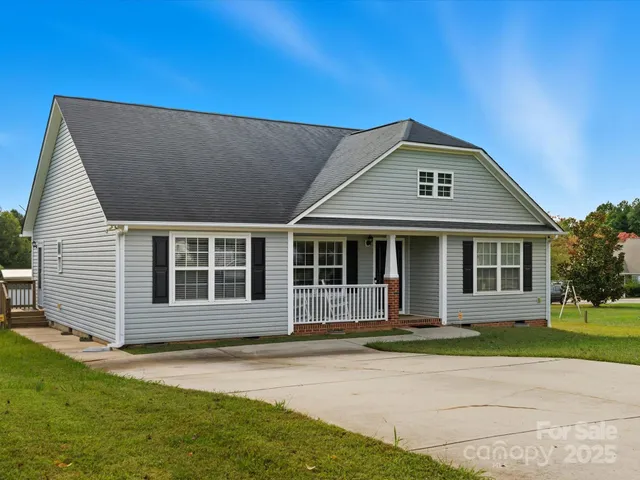 a view of a white house with a yard
