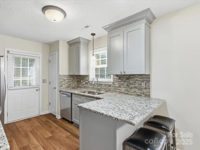 a kitchen with granite countertop cabinets stove and sink