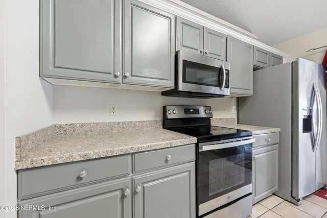 a kitchen with stainless steel appliances granite countertop white cabinets and a granite counter tops