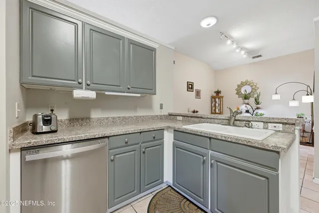 a kitchen with granite countertop a sink stainless steel appliances and cabinets