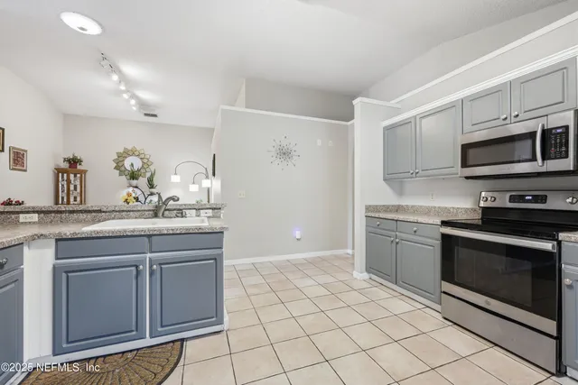 a kitchen with stainless steel appliances granite countertop a stove a sink and a microwave