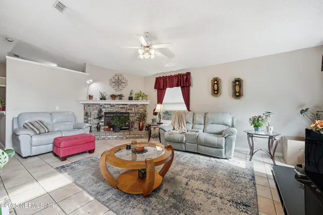 a living room with furniture a fireplace and a chandelier