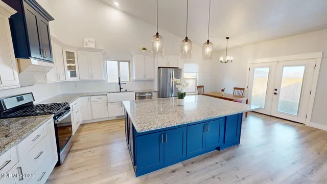 a kitchen with granite countertop kitchen island a sink stove and wooden floor