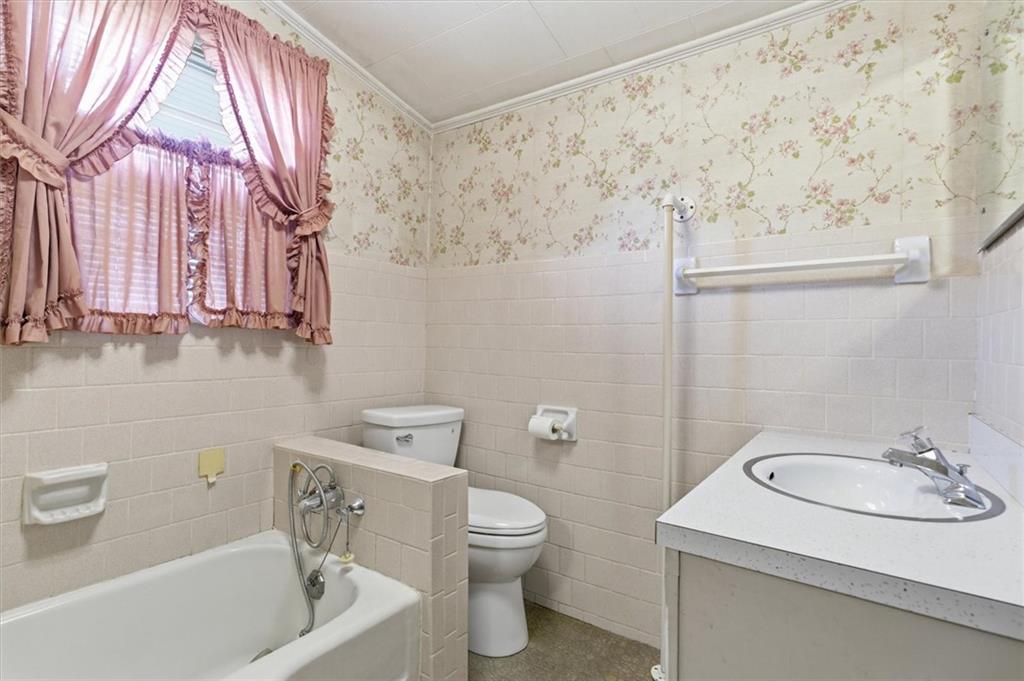 870 Marietta Road Canton, GA 30114 - Photo 17 of 43 a bathroom with a sink a toilet and shower curtain