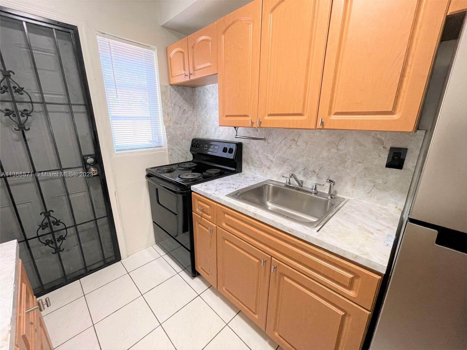 3530 Southwest 10th Street, Unit 2 Miami, FL 33135 - Photo 3 of 13 a kitchen with a sink a stove top oven and cabinets