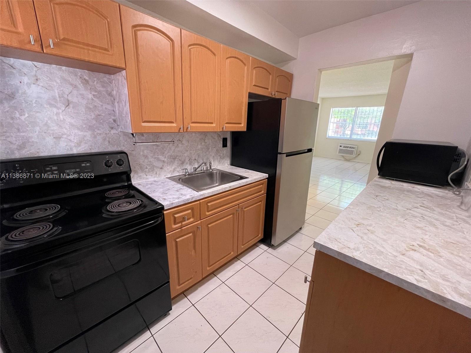3530 Southwest 10th Street, Unit 2 Miami, FL 33135 - Photo 4 of 13 a kitchen with stainless steel appliances granite countertop a sink stove and refrigerator
