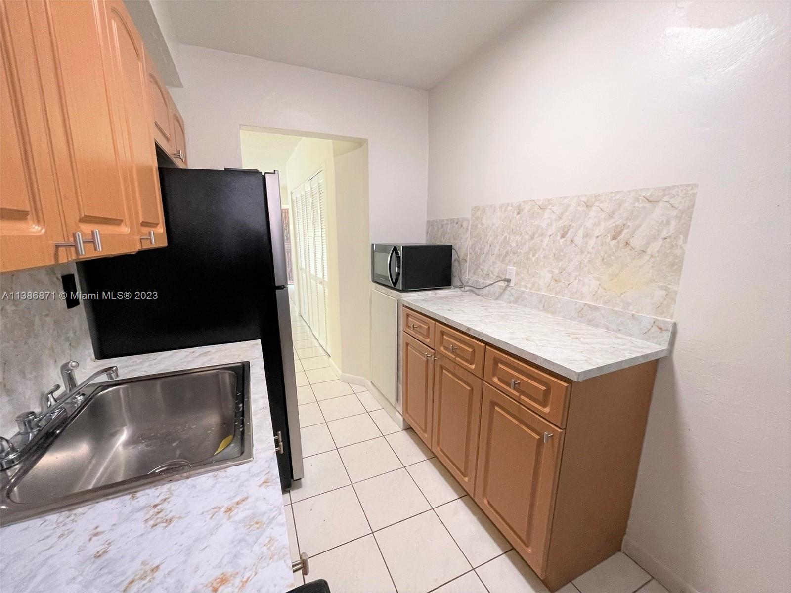3530 Southwest 10th Street, Unit 2 Miami, FL 33135 - Photo 5 of 13 a kitchen with stainless steel appliances a stove a microwave a sink and a refrigerator