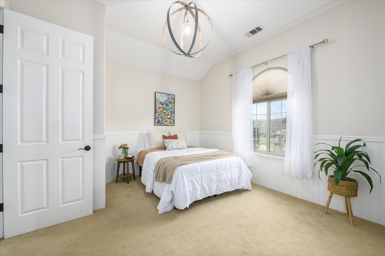 5880 Bumper Road El Dorado, CA 95623 - Photo 29 of 71 a spacious bedroom with a bed and a chandelier