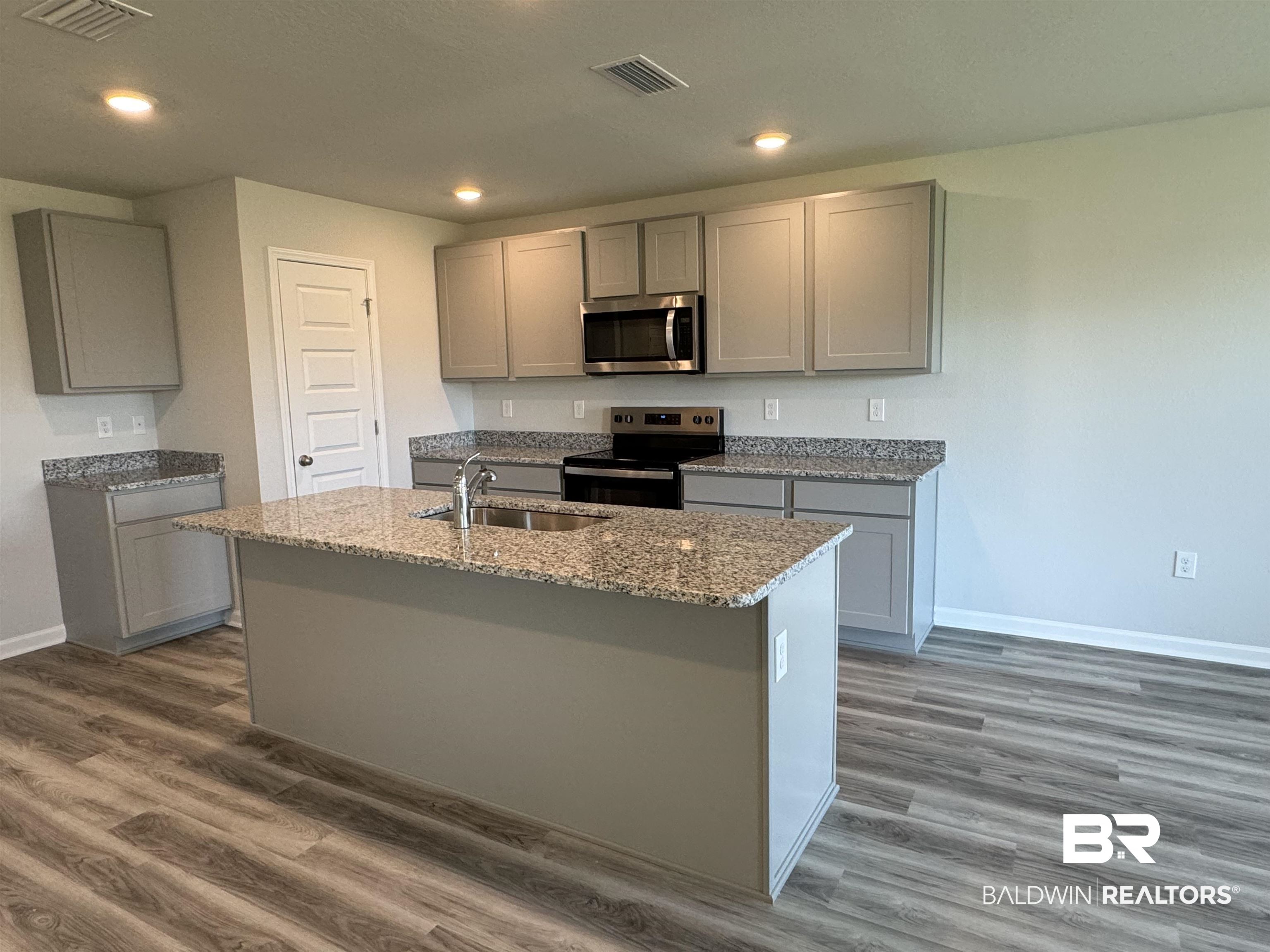 8880 Sea Star Circle Foley, AL 36535 - Photo 3 of 67 Kitchen featuring stainless steel appliances, gray cabinets, a center island with sink, and dark hardwood / wood-style flooring