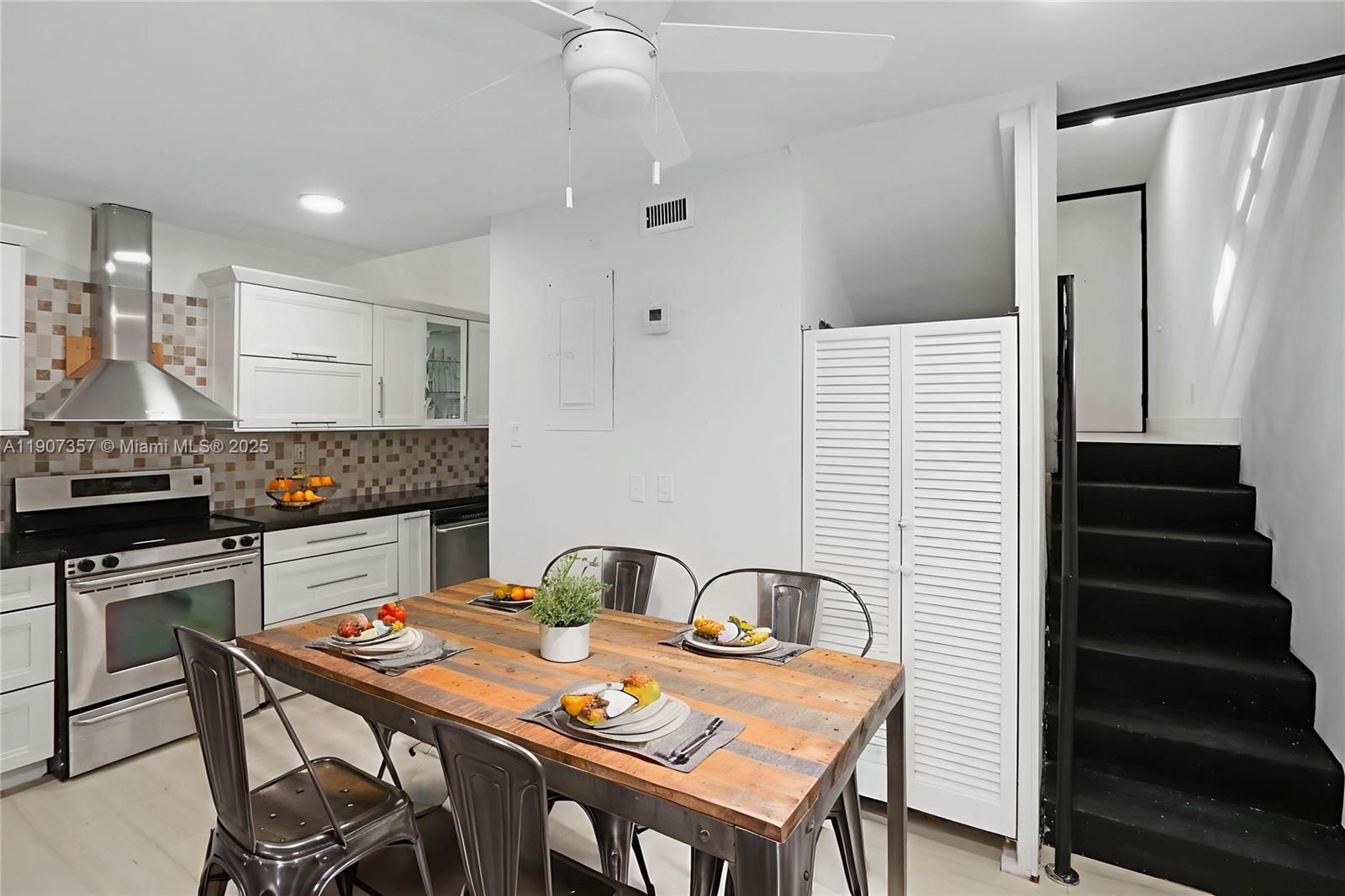 2778 Day Avenue, Unit 2 Miami, FL 33133 - Photo 6 of 21 a kitchen with stainless steel appliances kitchen island granite countertop a table chairs in it and wooden floors