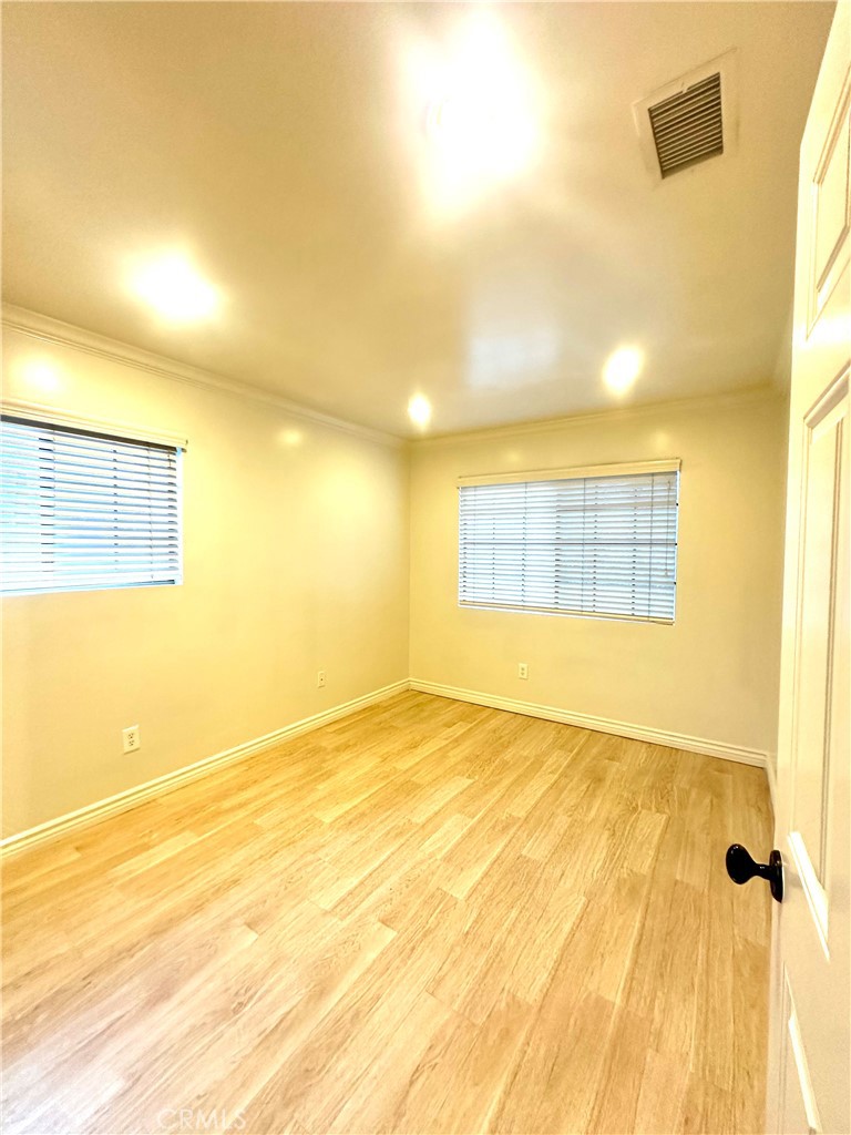 9356 19th Street, Unit A Rancho Cucamonga, CA 91701 - Photo 15 of 23 a view of an empty room with wooden floor and a window