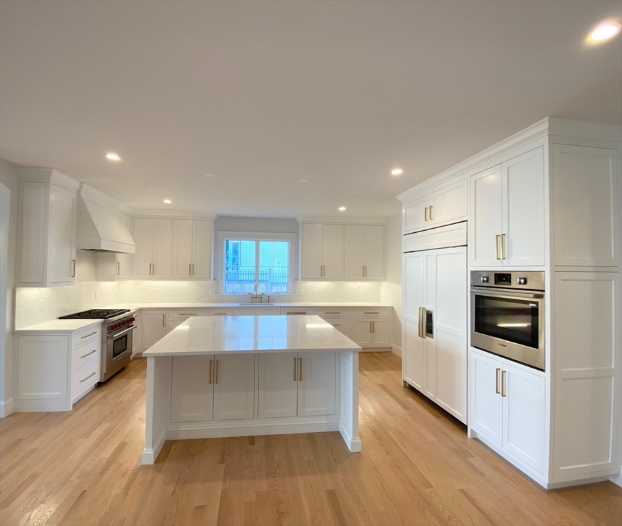 30 Gibson Street Needham, MA 02492 - Photo 4 of 17 a large kitchen with stainless steel appliances a large counter top and a stove top oven