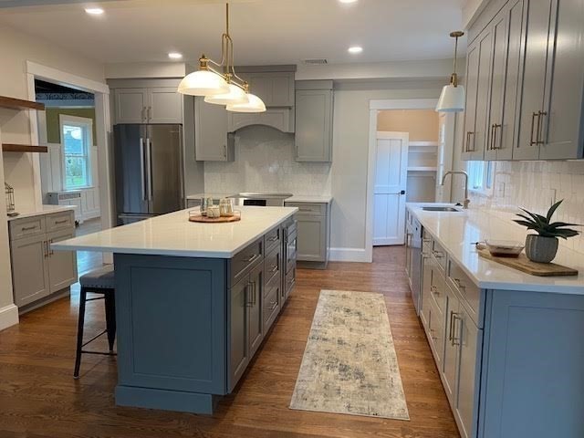 30 Gibson Street Needham, MA 02492 - Photo 5 of 17 a kitchen with kitchen island granite countertop a sink stove and cabinets