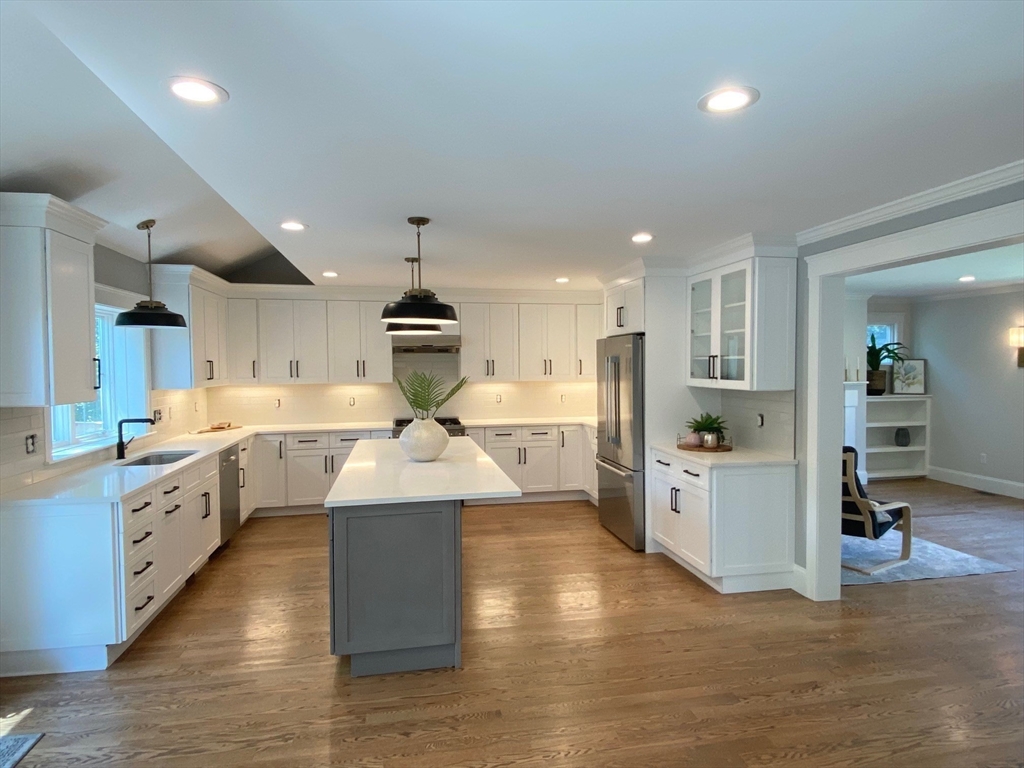 30 Gibson Street Needham, MA 02492 - Photo 6 of 17 a large kitchen with stainless steel appliances kitchen island a large counter top a sink a stove and a refrigerator