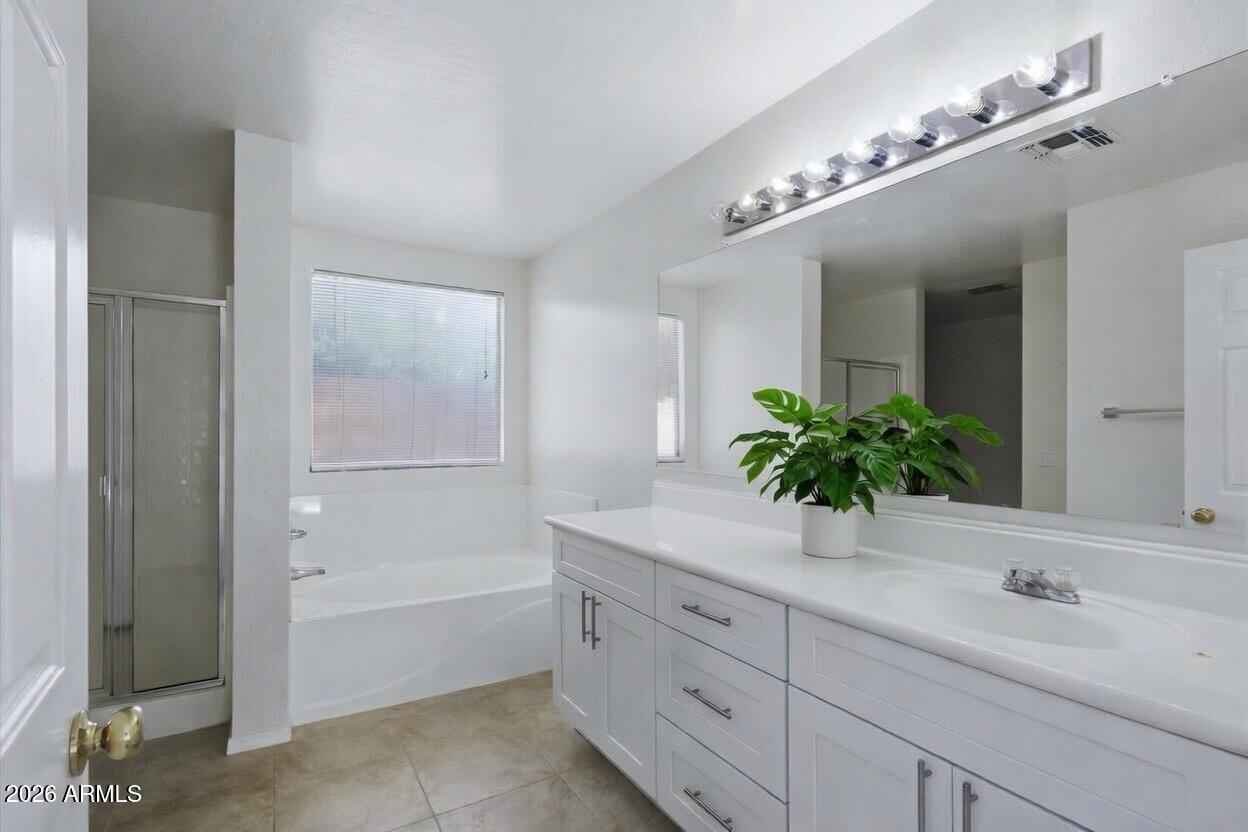 2933 West Maldonado Road Phoenix, AZ 85041 - Photo 14 of 27 a bathroom with a granite countertop sink a large mirror and shower