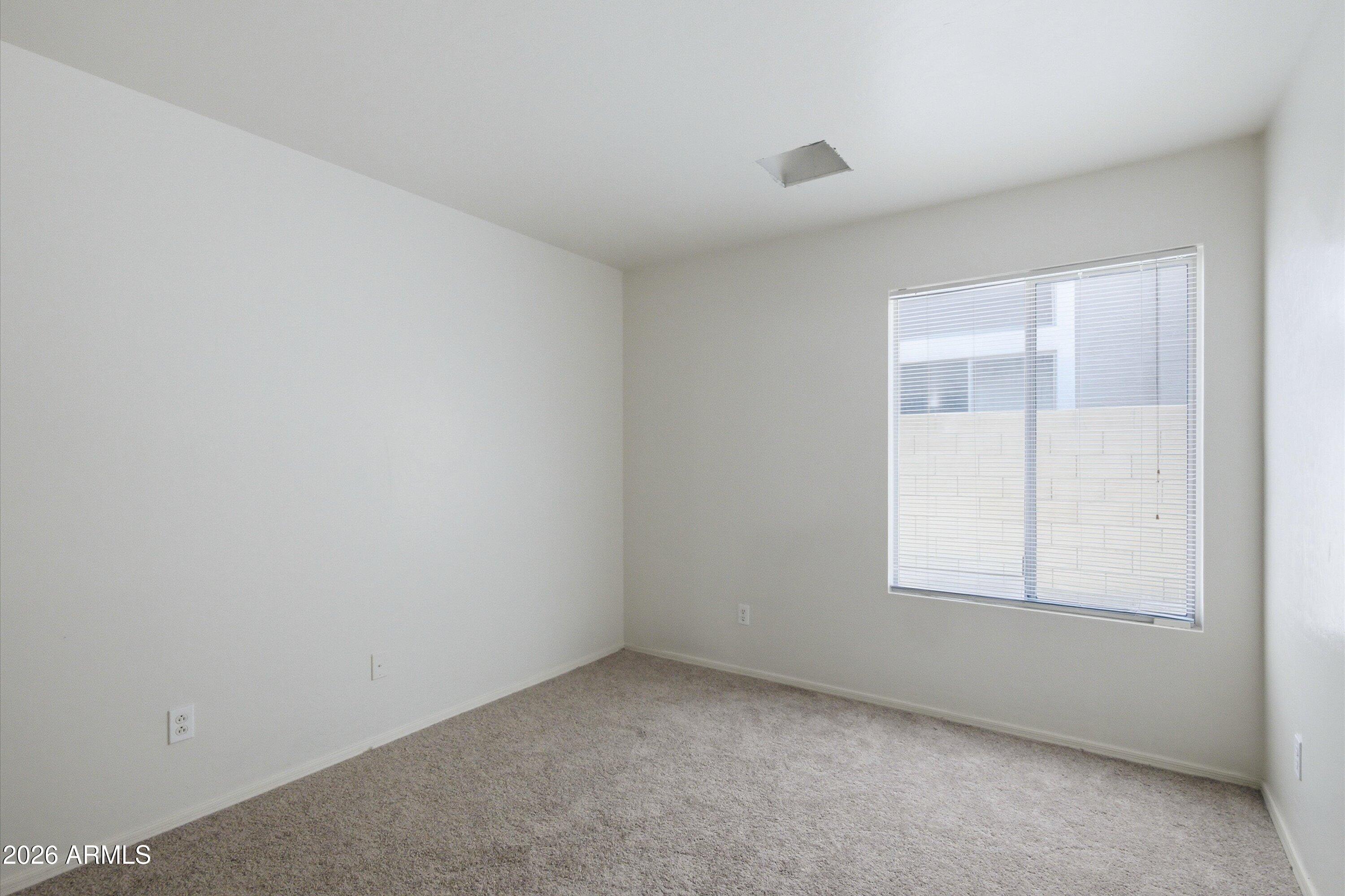 2933 West Maldonado Road Phoenix, AZ 85041 - Photo 21 of 27 an empty room with a window