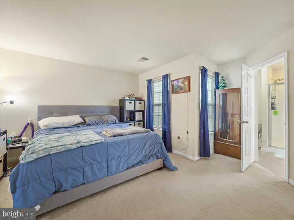 a spacious bedroom with a bed and a cabinets