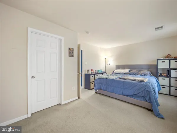 a spacious bedroom with a bed and a cabinets