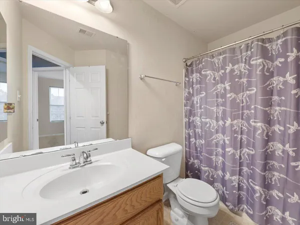 a bathroom with a sink a toilet and shower curtain