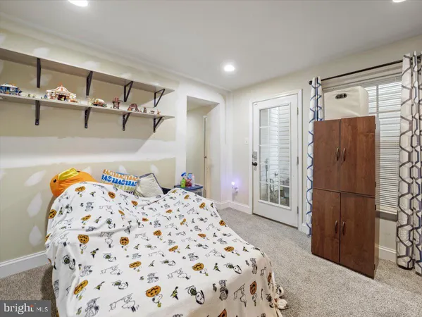 a bedroom with a bed and a refrigerator