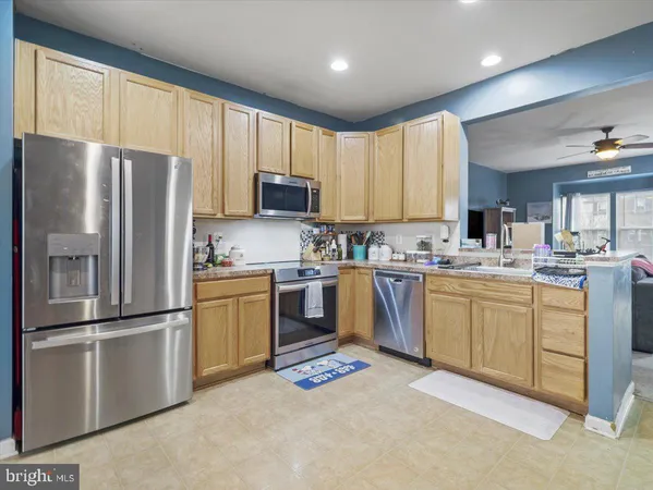 a kitchen with granite countertop stainless steel appliances a refrigerator sink and microwave