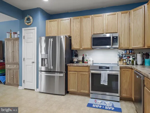 a kitchen with stainless steel appliances granite countertop a refrigerator stove and microwave