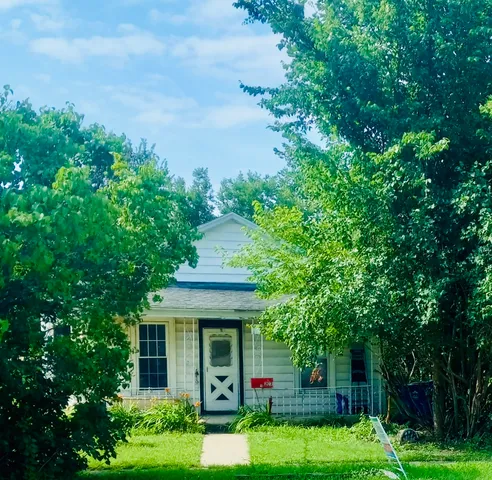 a front view of a house with a yard and green space
