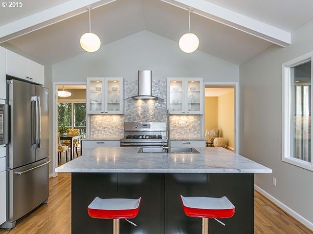 4140 Southwest 40th Place Portland, OR 97221 - Photo 5 of 16 a kitchen with stainless steel appliances a dining table and chairs