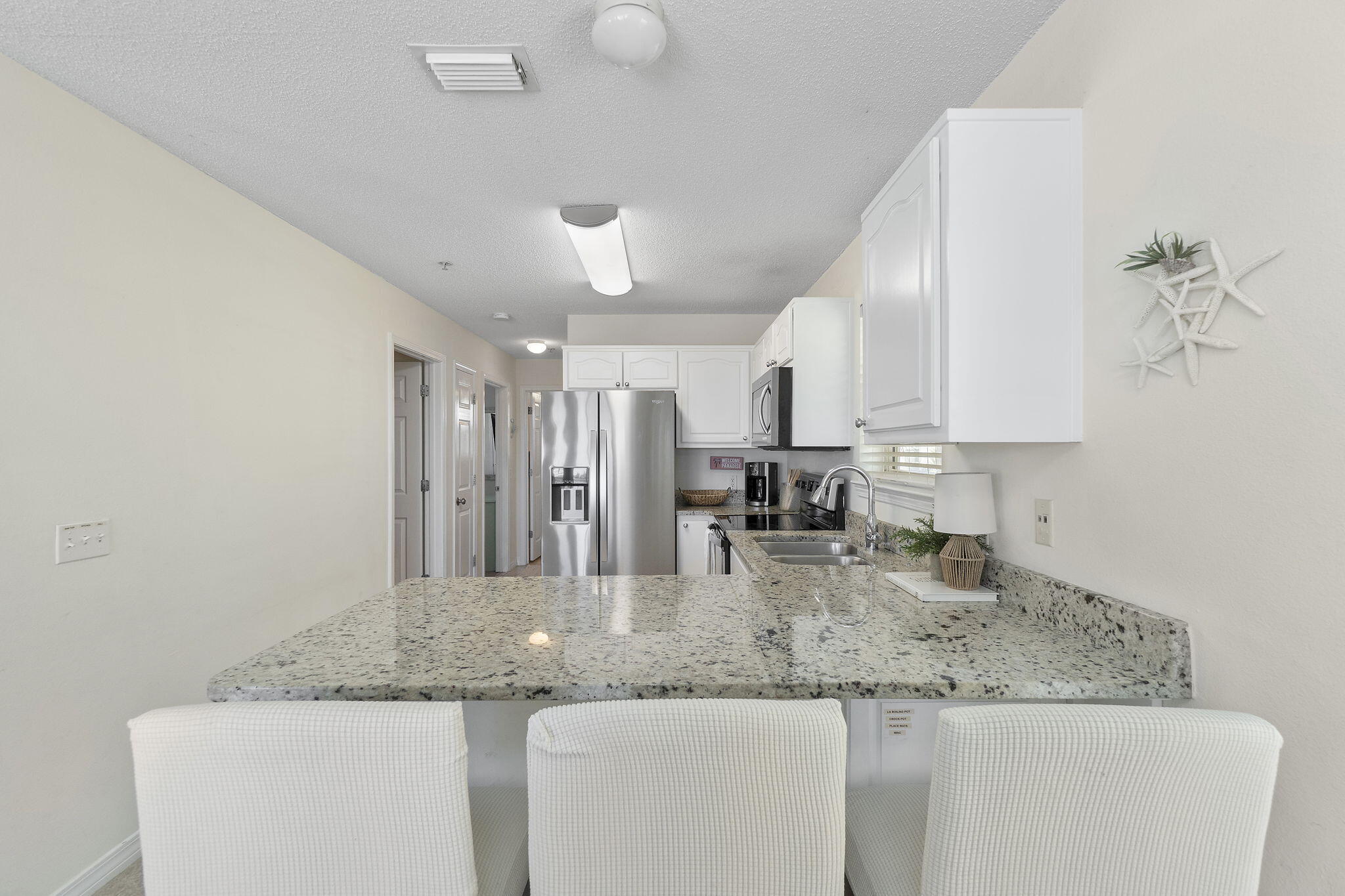 8436 Gulf Boulevard, Unit 321 Navarre, FL 32566 - Photo 24 of 57 a kitchen with granite countertop a sink a counter top space and cabinets