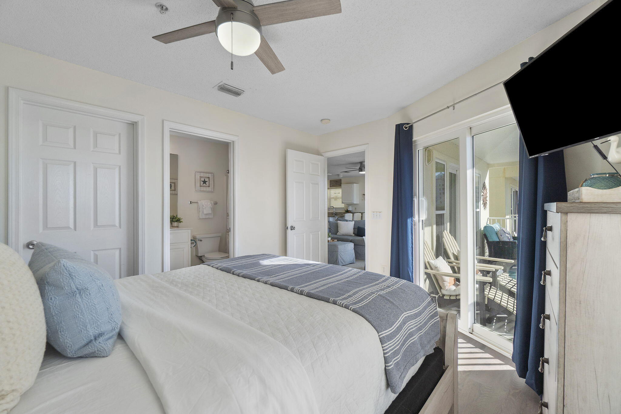 8436 Gulf Boulevard, Unit 321 Navarre, FL 32566 - Photo 31 of 57 a spacious bedroom with a bed and a flat screen tv